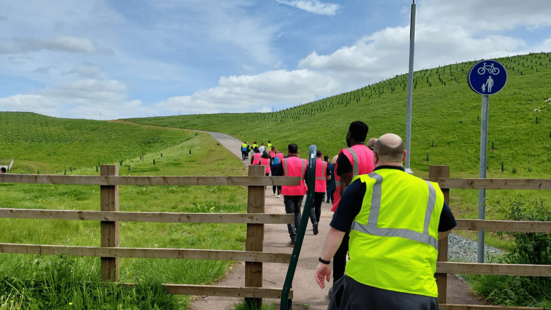 A group of people walking through a fence