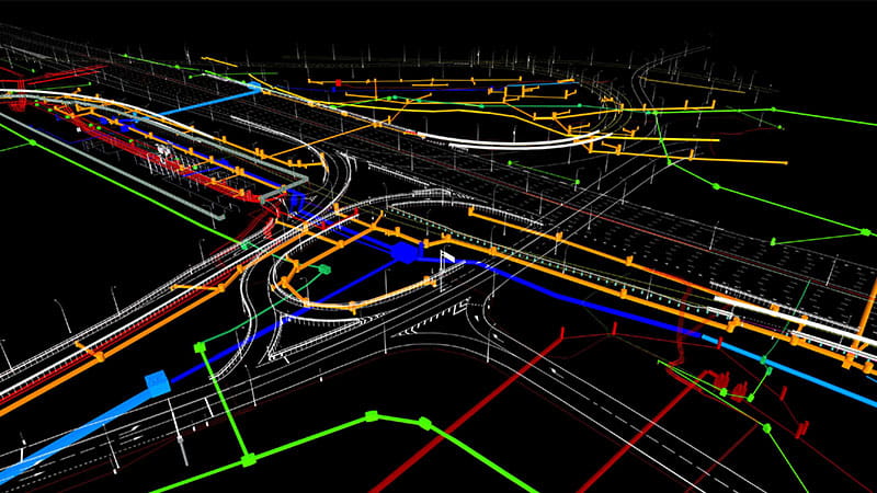 A complex 3D model of an infrastructure layout, featuring coloured lines representing roads, utilities, or construction plans, intersecting and running in various directions.